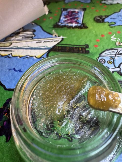 The same jar on October 26, two days later: the sandy heads have greased over into a glassy layer, with a greasy glob on the dab tool