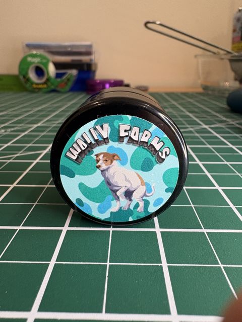 The Wally Farms lid: a cartoon dog on a teal background