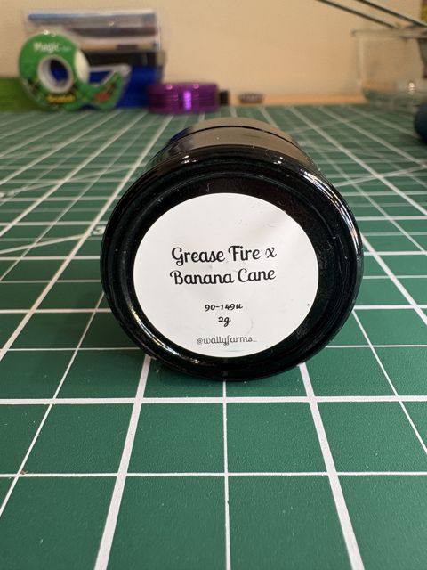 The jar label: Grease Fire x Banana Cane, 90-149u, 2g, @wallyfarms_